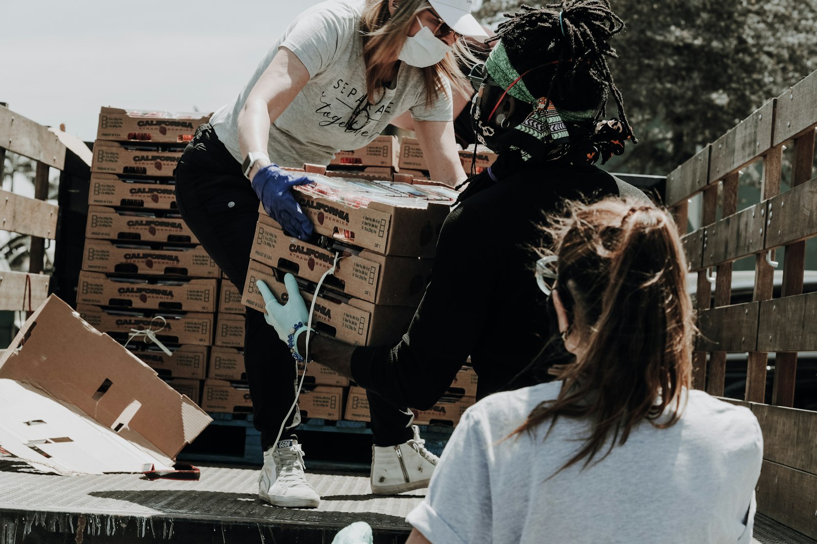 Community volunteers unloading produce together during a service effort.